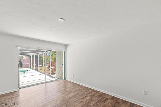 empty room featuring baseboards and wood finished floors