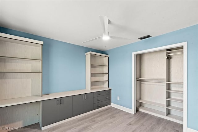 unfurnished bedroom with light wood-style floors, a ceiling fan, baseboards, visible vents, and a closet