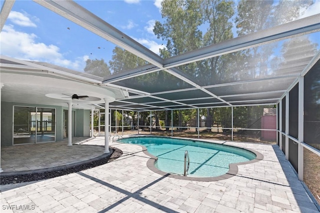 pool featuring glass enclosure, a patio, and a ceiling fan