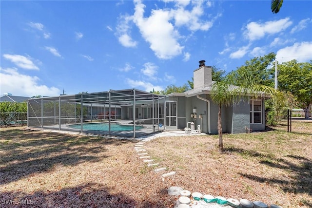 outdoor pool featuring a yard, a patio, fence, and a lanai