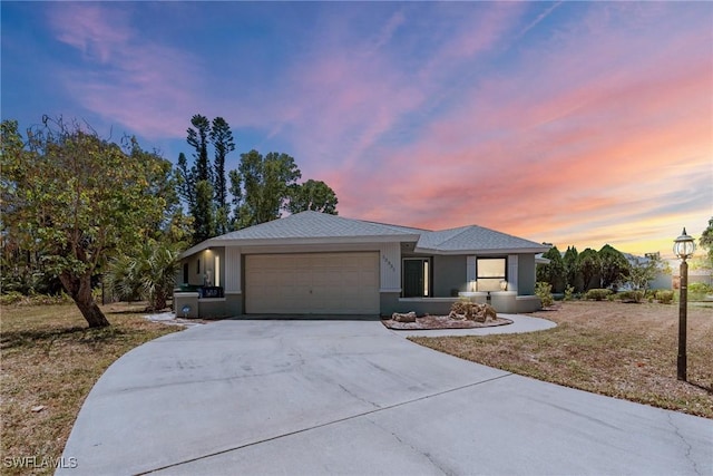 view of front of property with an attached garage, concrete driveway, and stucco siding