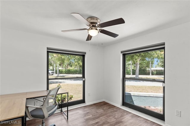 office area with baseboards, ceiling fan, plenty of natural light, and wood finished floors