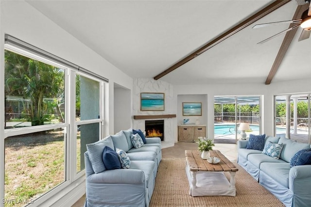 living area with ceiling fan, a fireplace, and beam ceiling