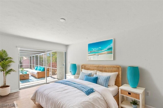 bedroom with baseboards, access to exterior, and wood finished floors