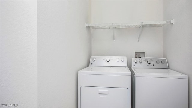 clothes washing area with separate washer and dryer and laundry area