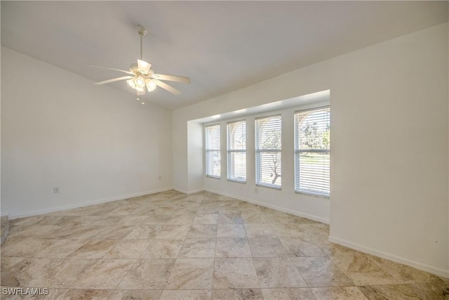empty room with lofted ceiling, a ceiling fan, and baseboards