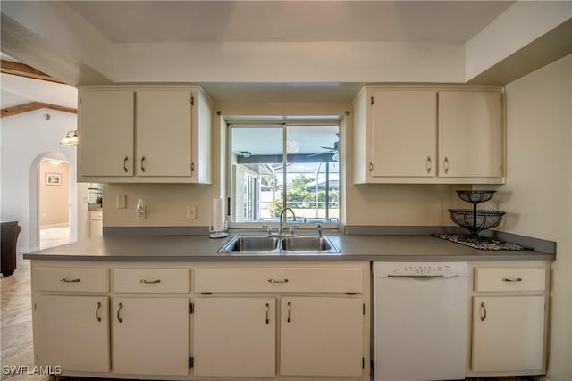 kitchen featuring white dishwasher, a sink, arched walkways, and white cabinets