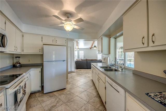 kitchen featuring white appliances, a sink, a ceiling fan, and white cabinetry