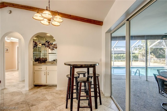 dining room with arched walkways, light tile patterned floors, and baseboards