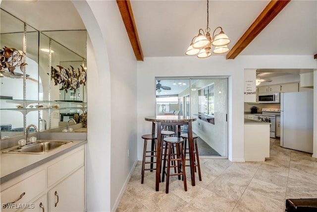 dining area with arched walkways, a chandelier, beamed ceiling, and baseboards