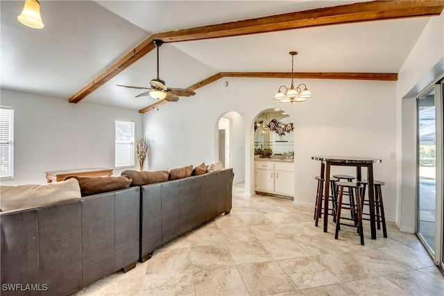 living area with arched walkways and ceiling fan