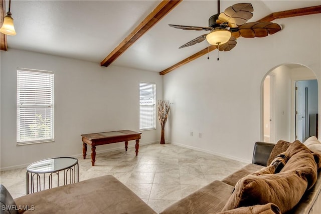 living room with arched walkways, ceiling fan, and baseboards