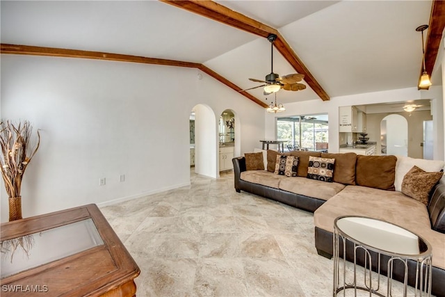 living area with arched walkways, a ceiling fan, and baseboards