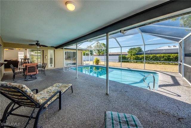 view of swimming pool featuring ceiling fan, a patio, and glass enclosure