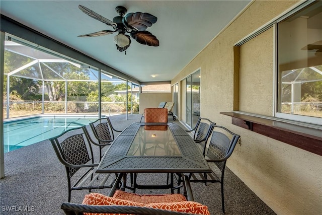 sunroom with ceiling fan, a swimming pool, and outdoor dining space