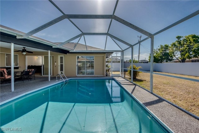 view of pool with fence, a patio, ceiling fan, and glass enclosure
