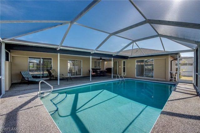 outdoor pool with a patio, a ceiling fan, and a lanai