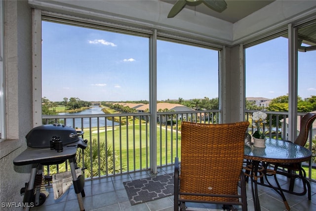 sunroom featuring a water view and tile patterned floors