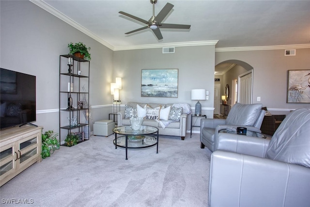 living area featuring carpet floors, arched walkways, ceiling fan, and visible vents