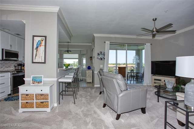 living room featuring crown molding, a ceiling fan, baseboards, and light carpet