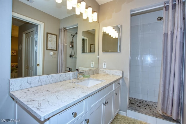 bathroom featuring vanity, a notable chandelier, and a tile shower