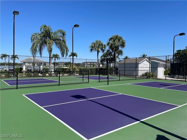 view of tennis court with fence and community basketball court