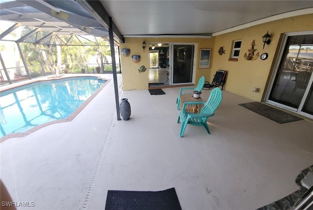 pool with glass enclosure and a patio area