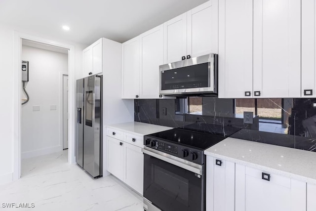 1111 SW Embers Ter, Cape Coral, FL 33991 - kitchen featuring stainless steel appliances, light marble finish flooring, white cabinetry, light stone countertops, and backsplash