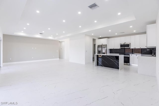 1111 SW Embers Ter, Cape Coral, FL 33991 - unfurnished living room featuring a raised ceiling and recessed lighting
