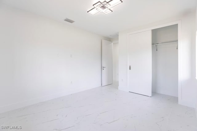 1111 SW Embers Ter, Cape Coral, FL 33991 - unfurnished bedroom featuring light marble finish flooring, a closet, and baseboards