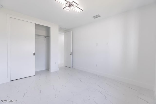 1111 SW Embers Ter, Cape Coral, FL 33991 - unfurnished bedroom featuring light marble finish floors, a closet, and baseboards