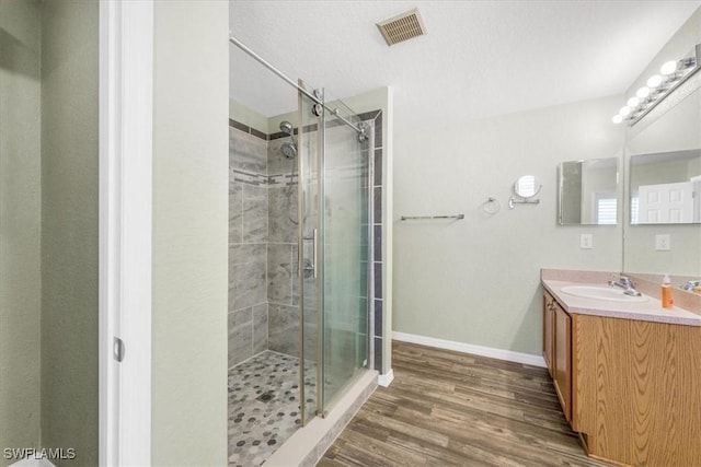 3210 31st St W, Lehigh Acres, FL 33971 - bathroom featuring vanity, a stall shower, wood finished floors, and visible vents