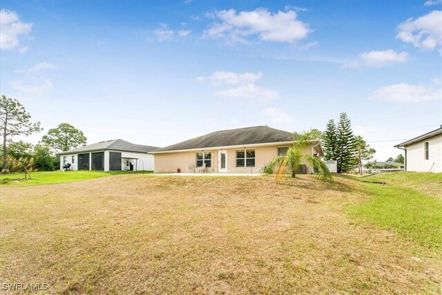 3210 31st St W, Lehigh Acres, FL 33971 - rear view of property featuring a lawn and stucco siding