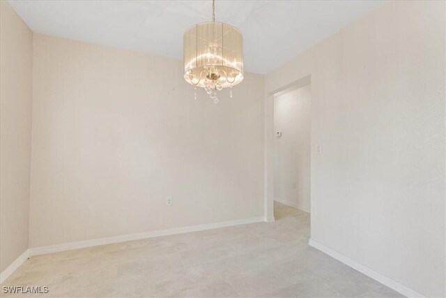 3210 31st St W, Lehigh Acres, FL 33971 - empty room featuring baseboards and a chandelier
