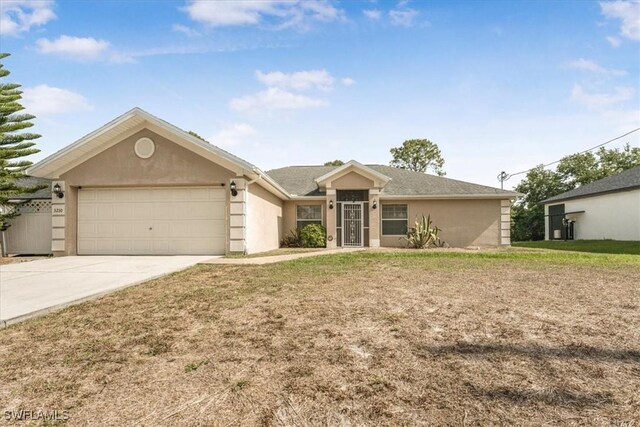3210 31st St W, Lehigh Acres, FL 33971 - ranch-style home featuring concrete driveway, stucco siding, a front lawn, and a garage