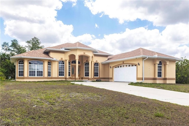 mediterranean / spanish home with a front yard, concrete driveway, a garage, and stucco siding