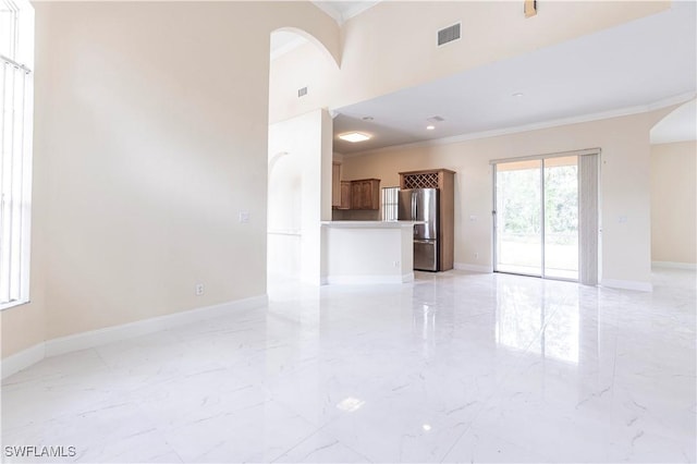 unfurnished living room with visible vents, ornamental molding, arched walkways, and marble finish floor