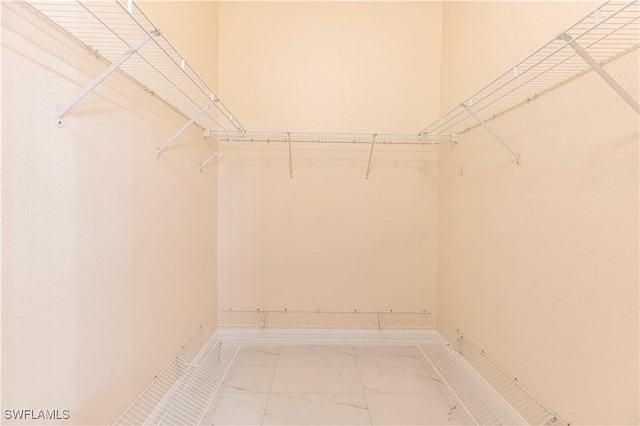 walk in closet with marble finish floor
