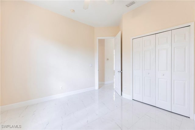 unfurnished bedroom with visible vents, a closet, baseboards, a ceiling fan, and marble finish floor
