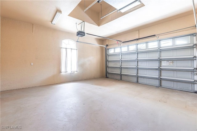 garage with a garage door opener and a textured wall