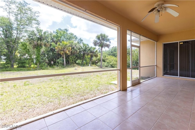 unfurnished sunroom with a ceiling fan