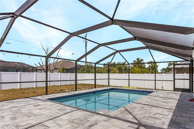 view of pool with fence, glass enclosure, a fenced in pool, and a patio area