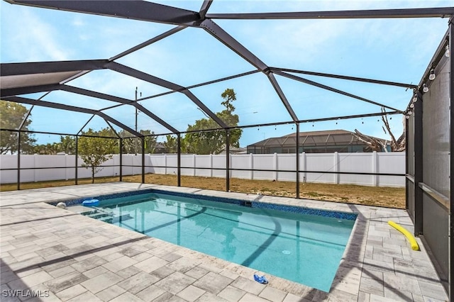 view of swimming pool with a patio, glass enclosure, a fenced backyard, and a fenced in pool