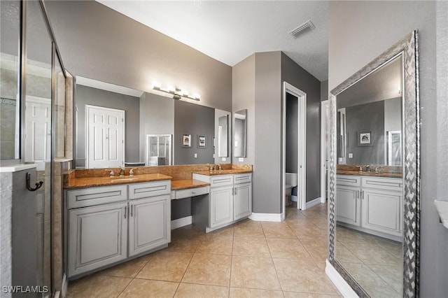 full bathroom with a sink, two vanities, visible vents, and tile patterned floors