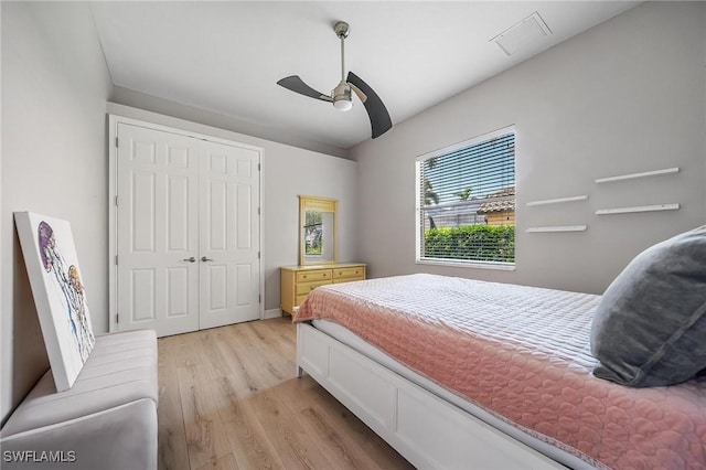 bedroom with a closet, ceiling fan, visible vents, and light wood-style floors