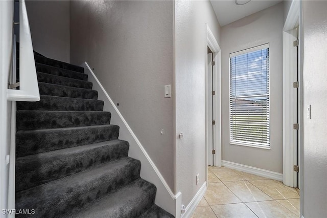 staircase with tile patterned floors and baseboards