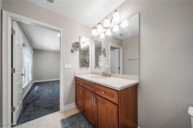 bathroom with tile patterned flooring, visible vents, vanity, and baseboards