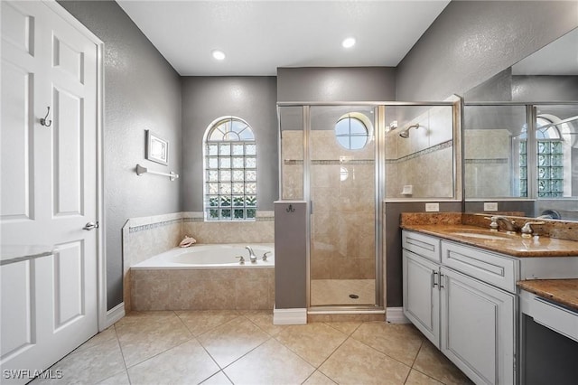 bathroom featuring vanity, a shower stall, a bath, and a textured wall