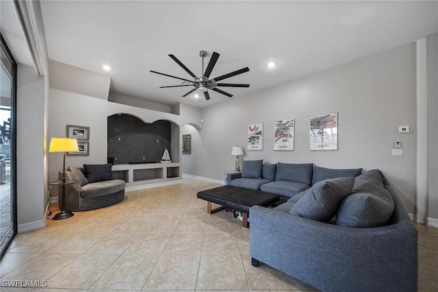 living room featuring recessed lighting, arched walkways, baseboards, a ceiling fan, and light tile patterned flooring