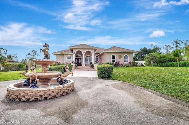 3020 Randall Blvd, Naples, FL 34120 - mediterranean / spanish-style home with a front yard, stucco siding, and curved driveway